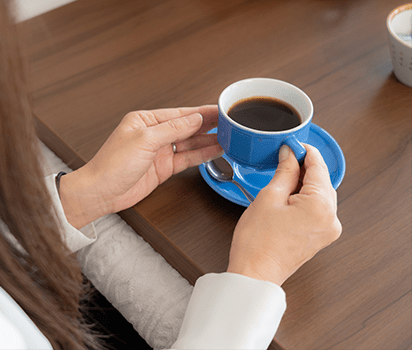 コーヒーカップを持つ人